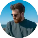 A man with a beard and sunglasses enjoying sunny weather outdoors, representing innovation and personal connection in modern digital communication.