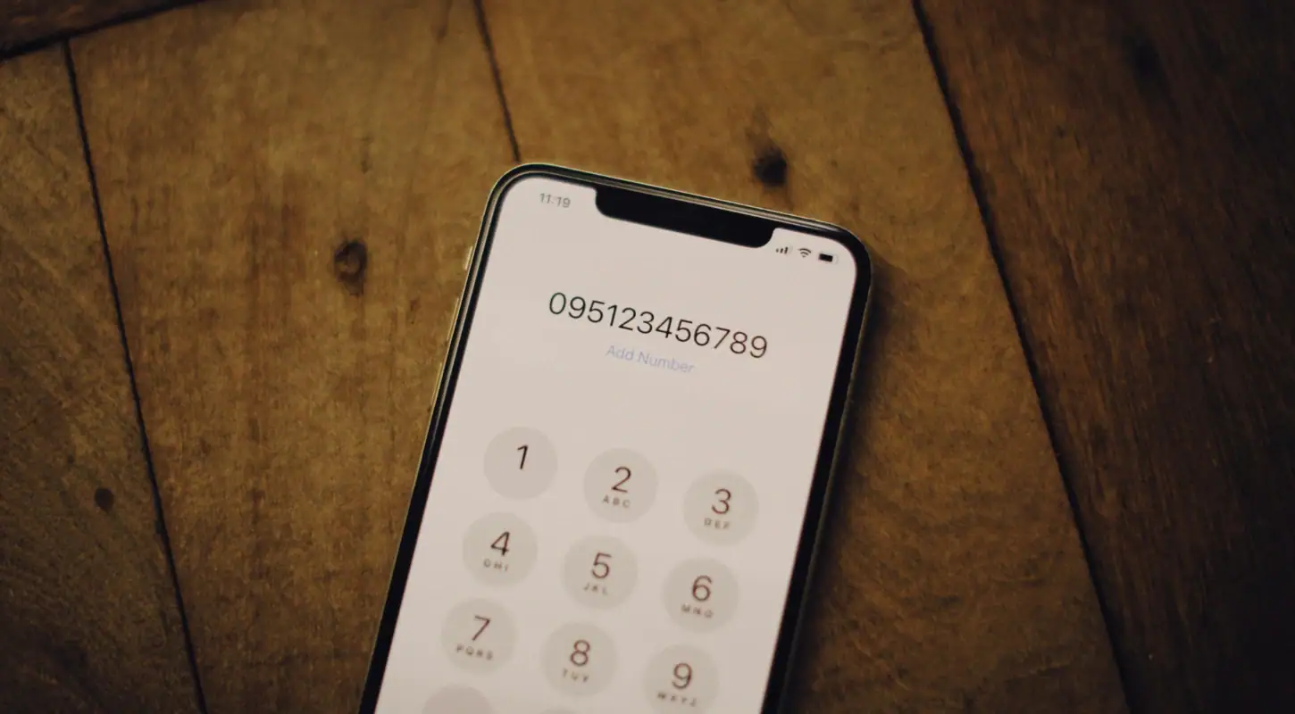 Smartphone displaying a dial pad with a second phone number, highlighting app features for private communication and number management.